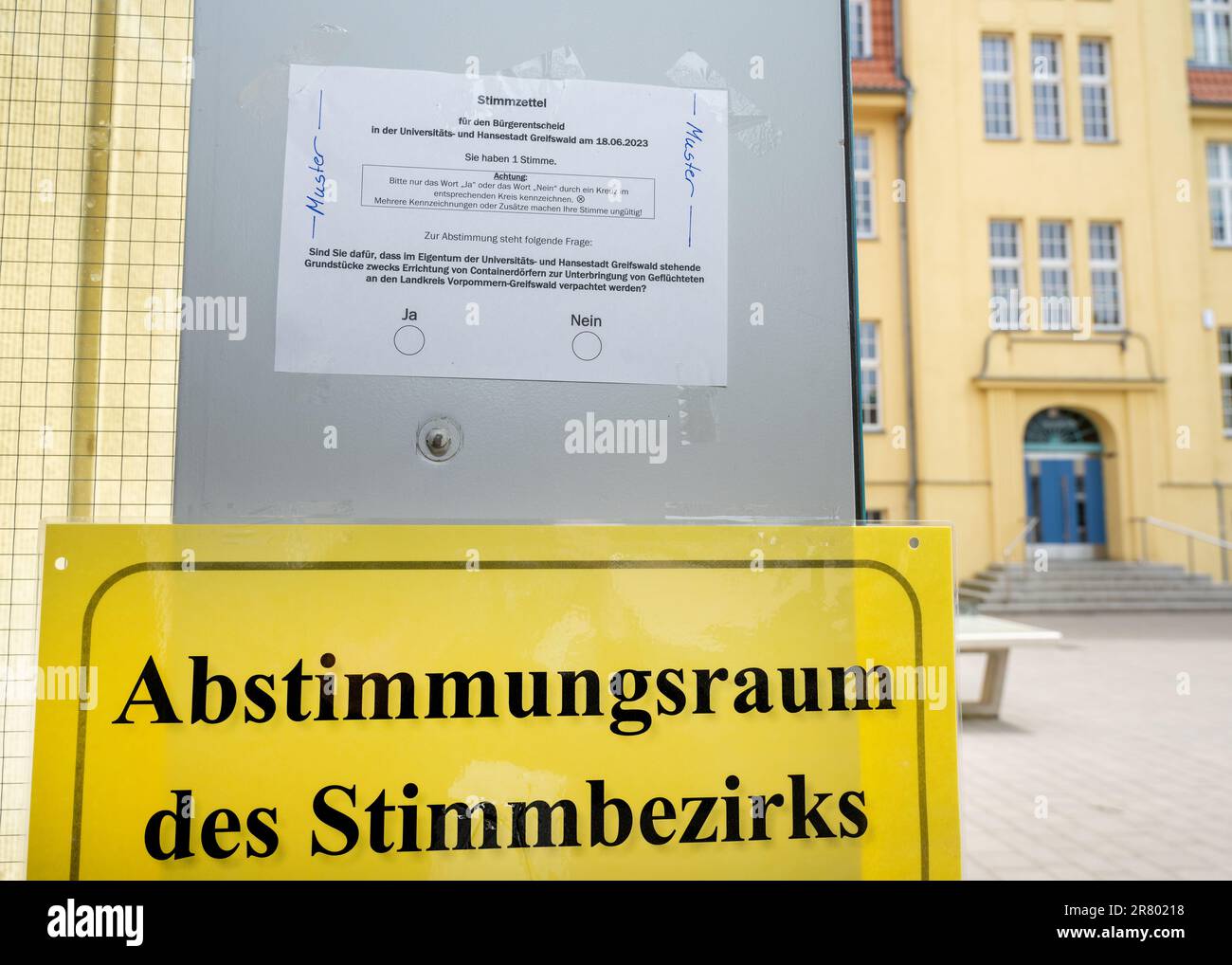 18 giugno 2023, Meclemburgo-Pomerania occidentale, Greifswald: Un campione di carta è appeso all'ingresso di una sala di voto. Greifswald può concedere in affitto terreni comunali al distretto per la sistemazione dei container per i rifugiati? Lo stesso giorno, i cittadini sono chiamati a votare in un referendum sulla questione. All'inizio dell'anno si è manifestata una forte protesta contro un grande impianto di alloggi per container nella città anseatica. I piani corrispondenti sono stati rimossi dalla tabella. La protesta ha dato luogo a una petizione per un referendum, che ha portato alla decisione raccogliendo migliaia di segnali Foto Stock