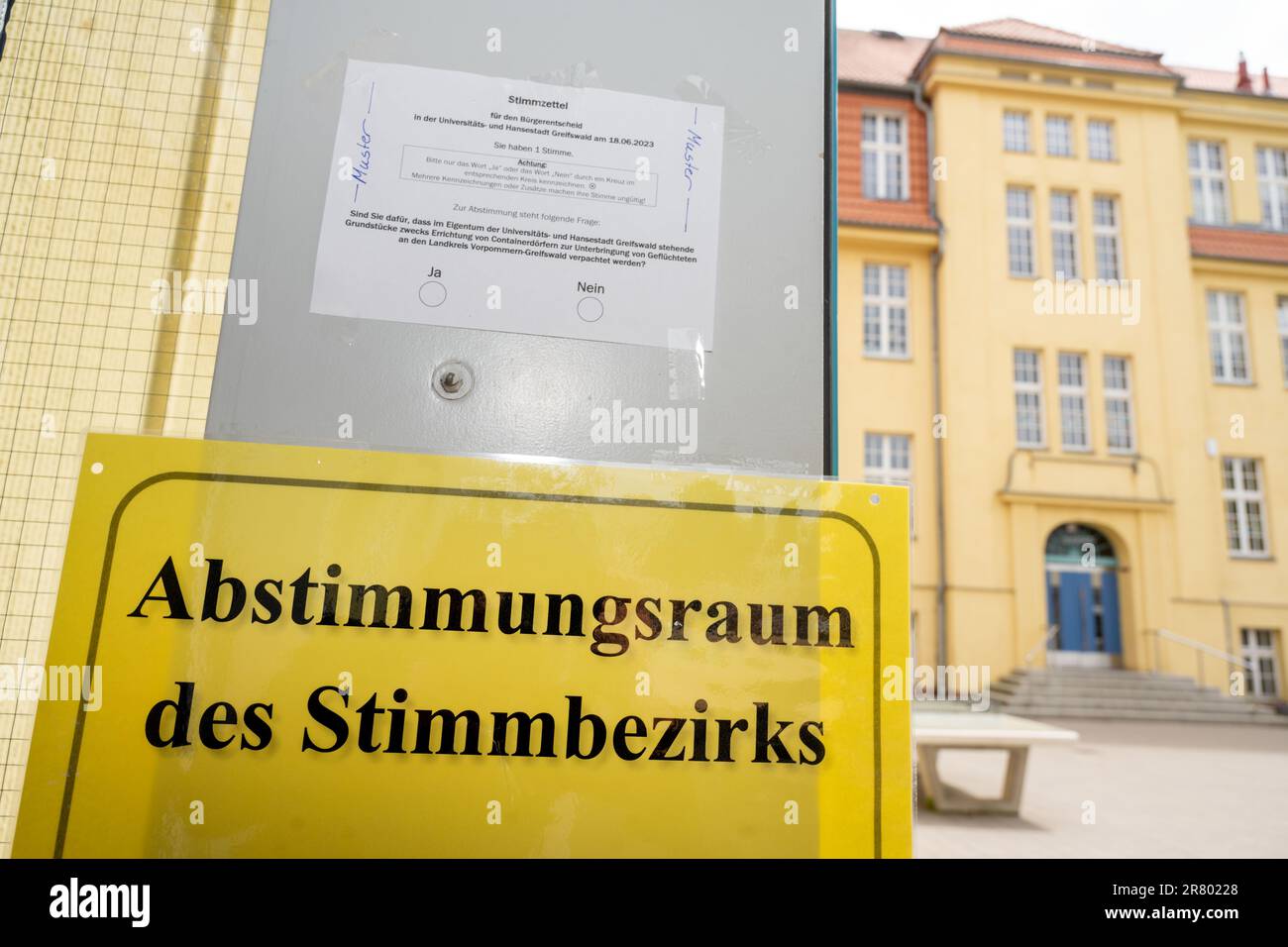 18 giugno 2023, Meclemburgo-Pomerania occidentale, Greifswald: Un campione di carta è appeso all'ingresso di una sala di voto. Greifswald può concedere in affitto terreni comunali al distretto per la sistemazione dei container per i rifugiati? Lo stesso giorno, i cittadini sono chiamati a votare in un referendum sulla questione. All'inizio dell'anno si è manifestata una forte protesta contro un grande impianto di alloggi per container nella città anseatica. I piani corrispondenti sono stati rimossi dalla tabella. La protesta ha dato luogo a una petizione per un referendum, che ha portato alla decisione raccogliendo migliaia di segnali Foto Stock