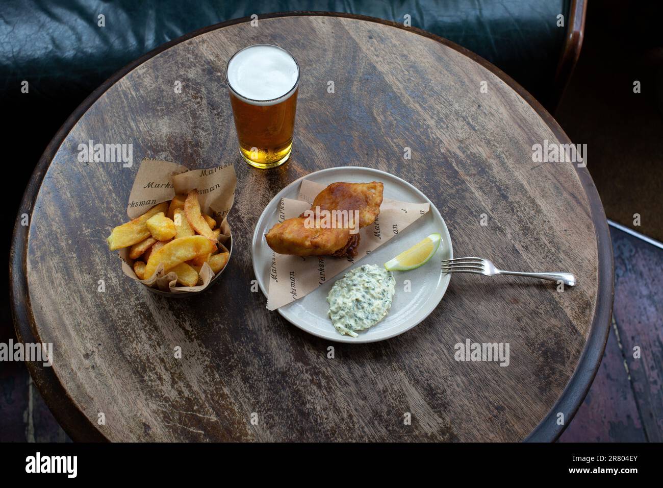 Pesce e patatine fritte con pinta di birra nel pub o nel ristorante Foto Stock