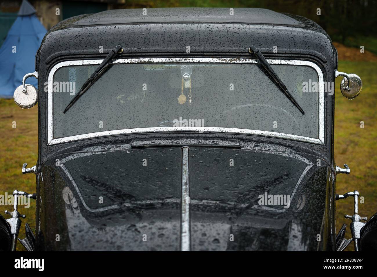 Parabrezza di un'auto retrò in gocce di pioggia. Foto Stock