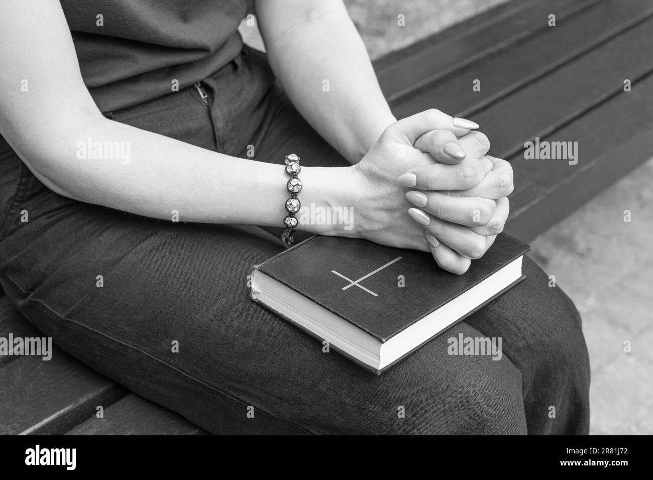 donna che chiede a dio tenendo la bibbia in grembo. La donna chiama Dio per aiuto. donna che recita una preghiera Foto Stock