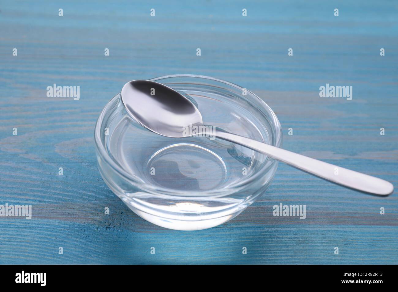 Ciotola di sciroppo di fruttosio su tavola di legno azzurro chiaro Foto Stock