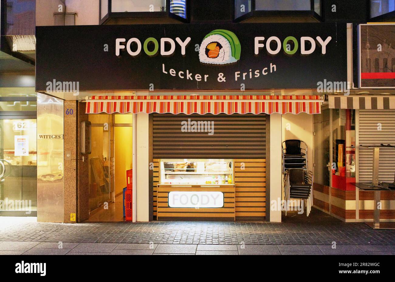 Scena notturna di un negozio chiuso con il nome strano e divertente di Foody Foody, a Coblenza, in Germania. Foto Stock