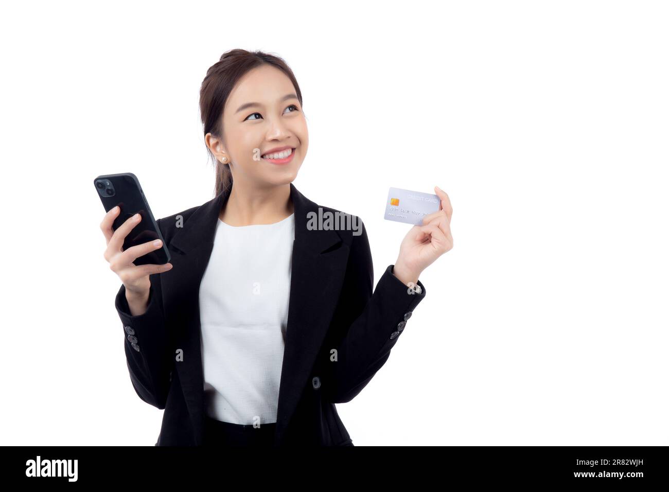 Ritratto giovane donna asiatica d'affari tenere la carta di credito e cercando smartphone per lo shopping online isolato sfondo bianco, donna d'affari cercando debi Foto Stock