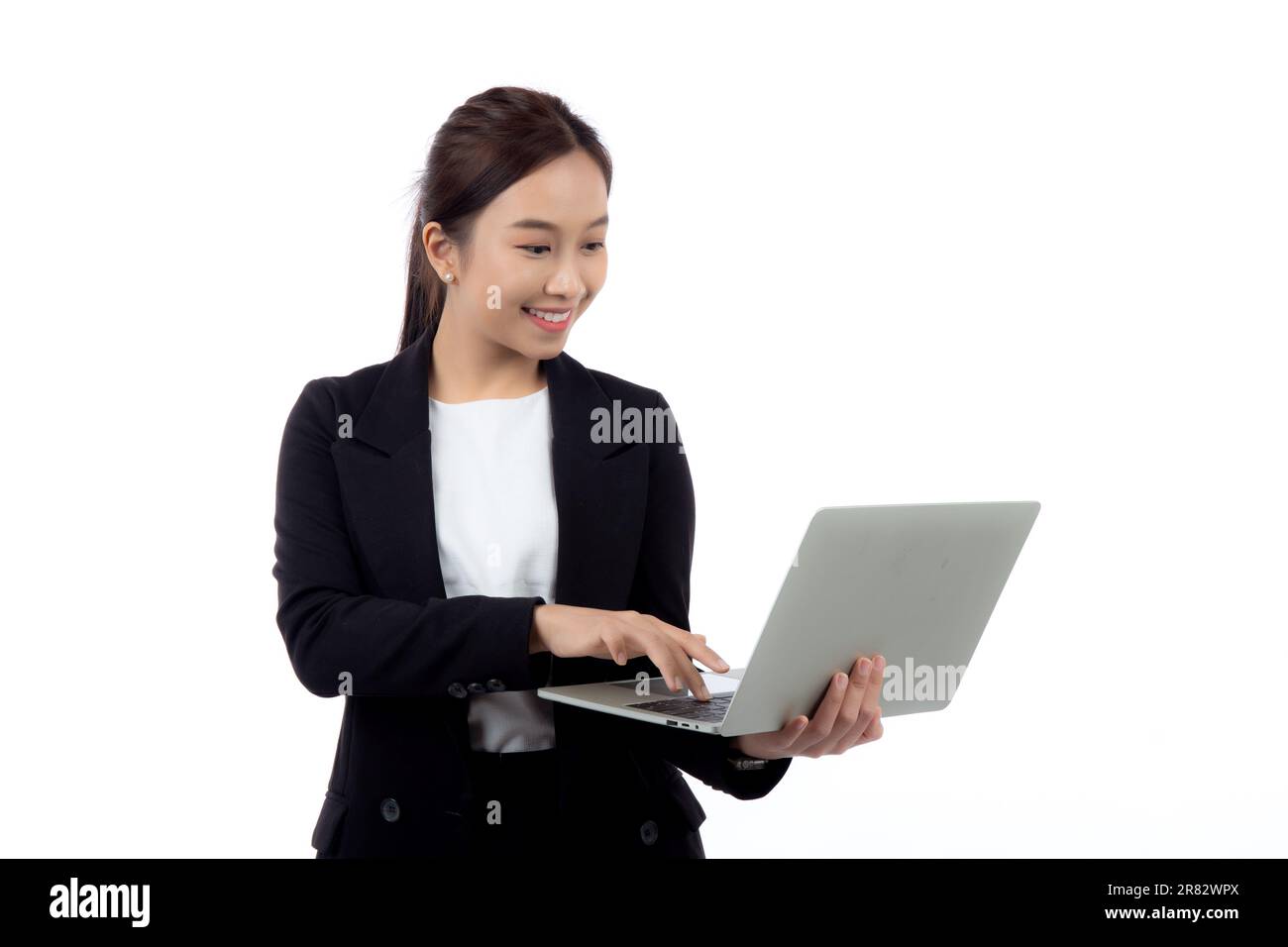 Ritratto giovane donna asiatica d'affari in piedi lavoro sul computer portatile a Internet online isolato su sfondo bianco, donna d'affari in tuta sicuro Foto Stock