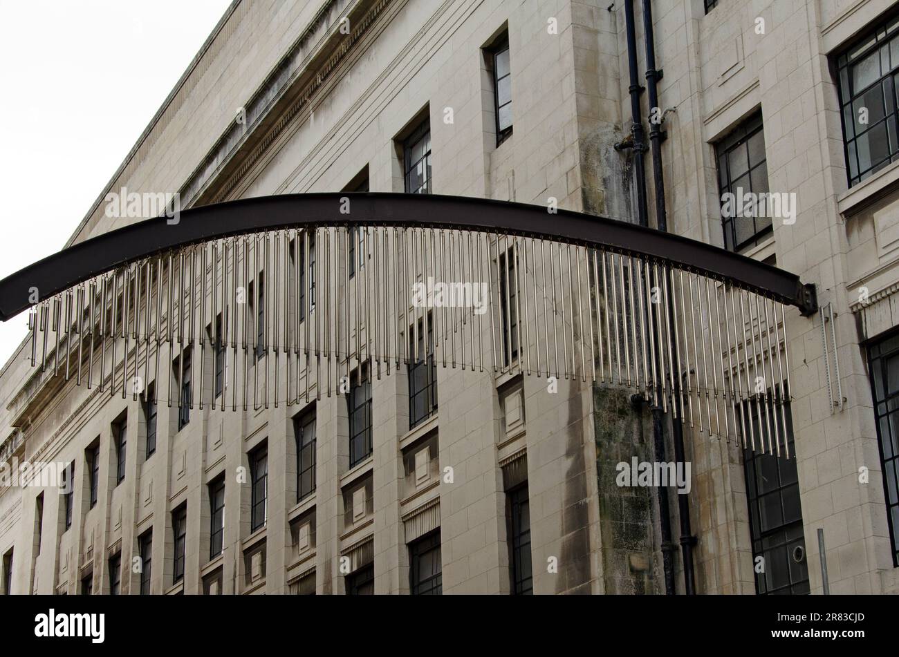 Campane tubolari metalliche sospese tra due edifici Foto Stock