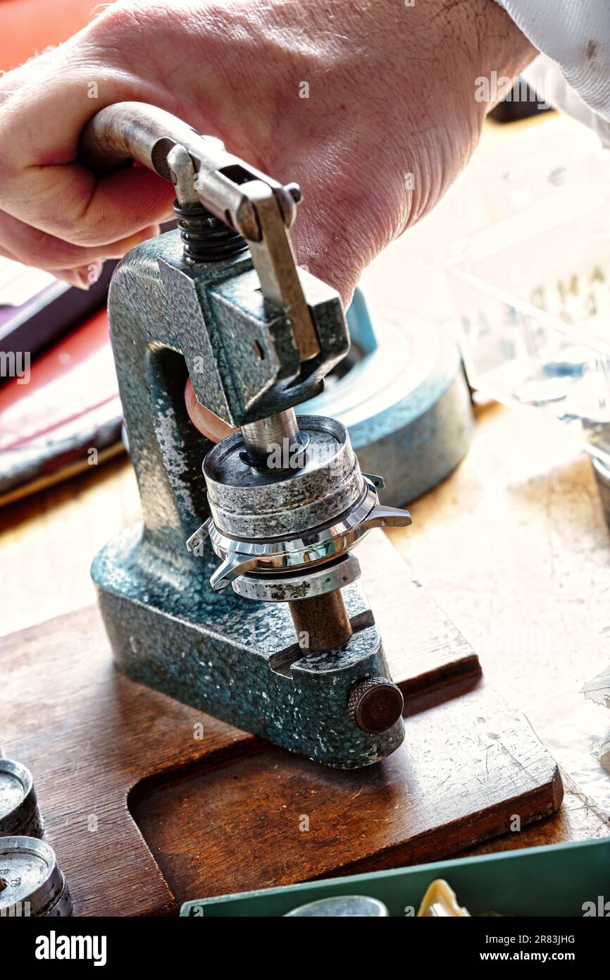 In un ambiente vintage e a vapore, mani esperte di un'opera artigianale su componenti intricati dell'orologio. Orologi, ingranaggi, molle definiscono la precisione, aesthet Foto Stock