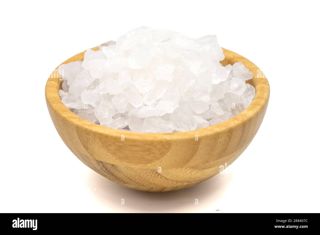 Sale di limone o acido citrico isolato su fondo bianco. Acido citrico o sale di limone in ciotola di legno. Primo piano Foto Stock