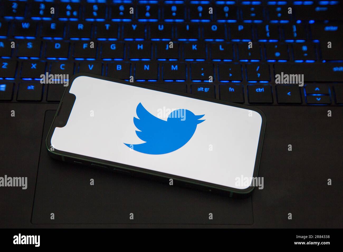 Caricamento dell'app Twitter su un iPhone su un computer portatile Foto Stock
