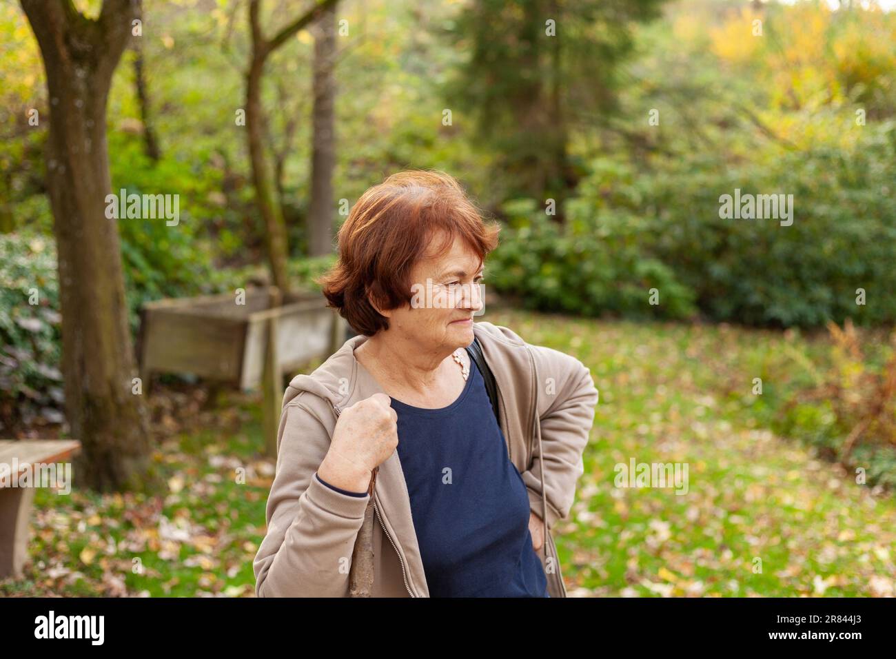 Donna anziana che corre nel parco in autunno. Concetto di stile di vita sano. Foto Stock