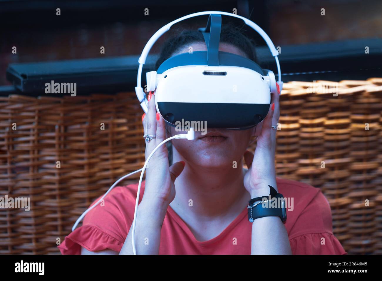 Rimini, Italia - 15 giugno 2023: Metaverse Digital Virtual Reality Technology di una donna con occhiali e visore VR connesso allo spazio virtuale Foto Stock