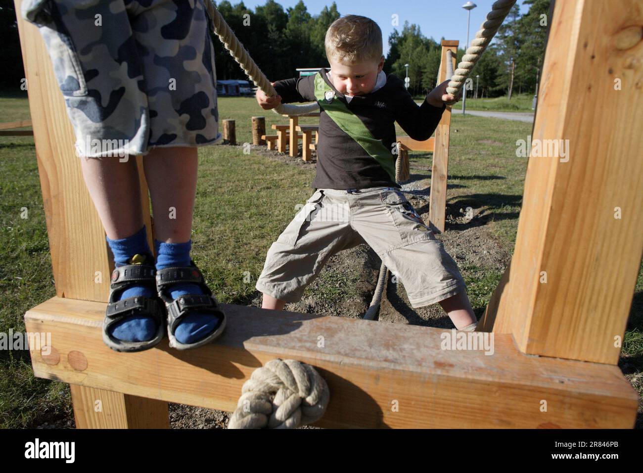 Un bambino autistico si allena sulle funi da passeggio in un parco giochi a Stoccolma, Svezia, Foto Stock