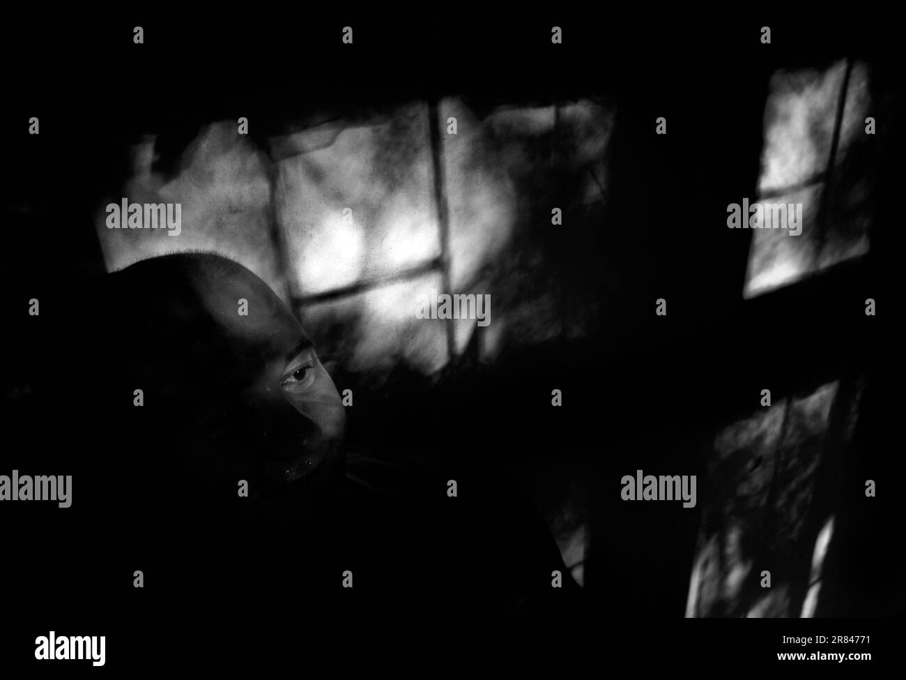 Ritratto oscurato di uno zingaro, seduto nel buio nella casa della mucca convertita, dove vive in wile per due anni. Foto Stock