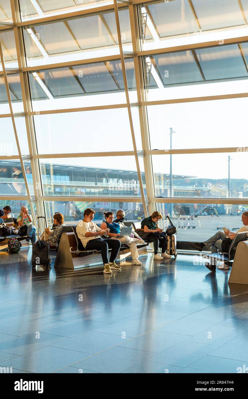 Persone in attesa di voli all'aeroporto di Zurigo, Svizzera Foto Stock