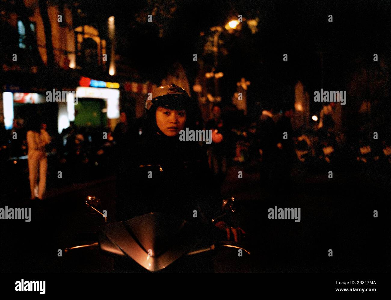 Una giovane motociclista femminile corre lungo la strada ad Hanoi, Vietnam. Foto Stock