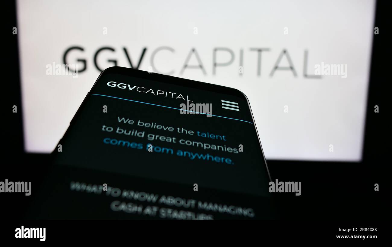 Smartphone con sito web della società di investimento GGV Capital sullo schermo di fronte al logo aziendale. Messa a fuoco in alto a sinistra del display del telefono. Foto Stock