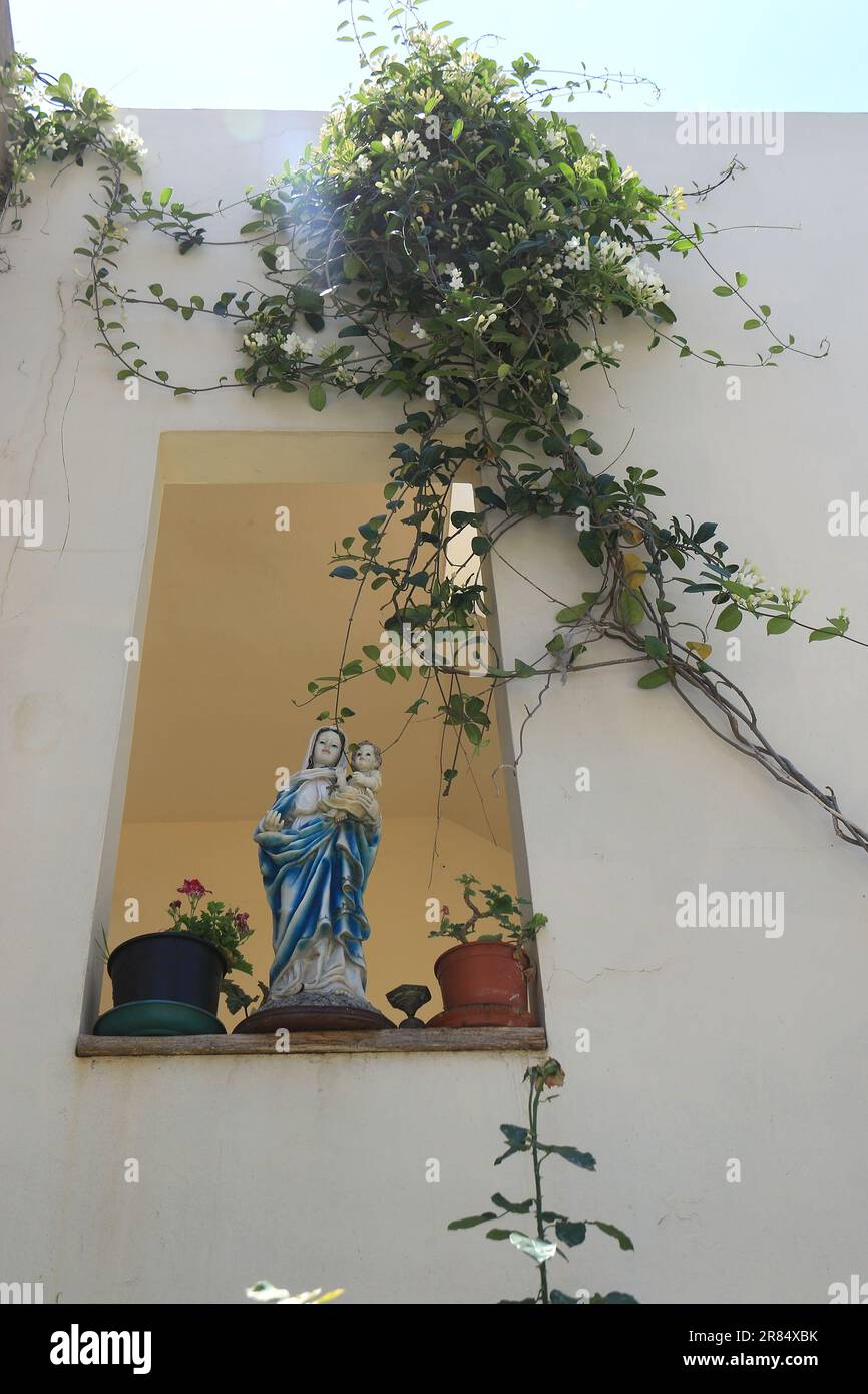 Una statua di Maria che tiene Gesù bambino in una finestra a Batroun, Libano. Foto Stock