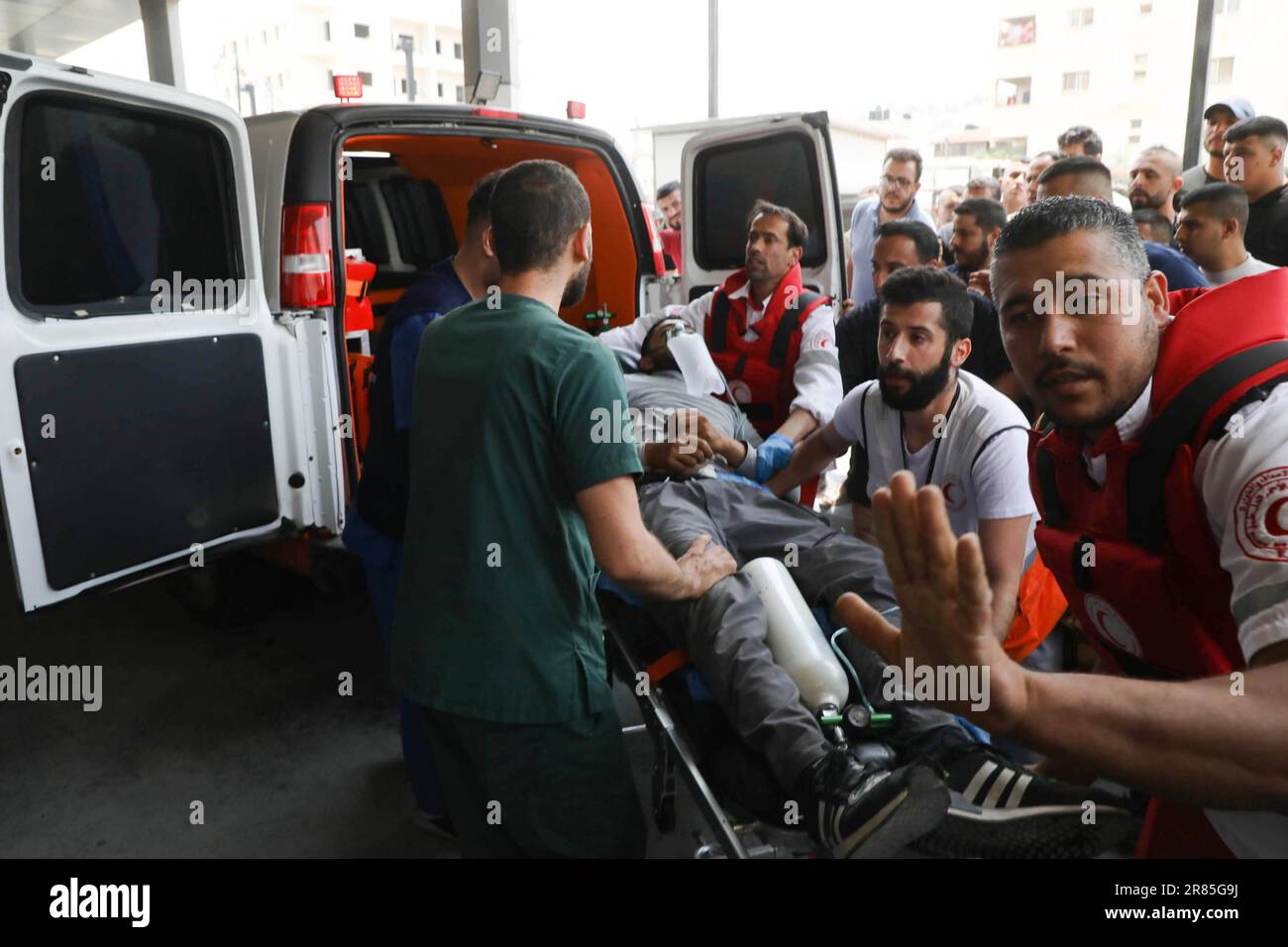 19 giugno 2023: Jenin, Cisgiordania, Palestina. 19 giugno 2023. Un palestinese ferito viene salvato dai paramedici a seguito degli scontri tra le forze israeliane e i palestinesi nel campo profughi palestinesi di Jenin, nella parte settentrionale della Cisgiordania. Cinque palestinesi, tra cui un ragazzo di 15 anni, sono stati uccisi dalle forze israeliane durante un'incursione sotto copertura israeliana nel campo profughi di Jenin prima dell'alba di lunedì. Gli elicotteri israeliani di apache hanno sparato missili contro i militanti palestinesi durante il raid. Sette soldati israeliani sono stati feriti da improvvisati dispositivi esplosivi posti nelle loro jeep (Credit Image: © Mohammed Foto Stock