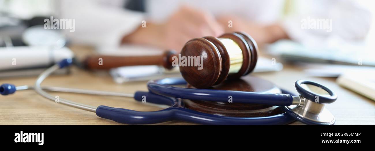 Primo piano del giudice del medico stetoscopio in background scrivendo note Foto Stock