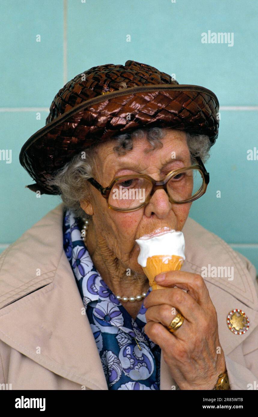 Anziana donna anziana pensionato che mangia gelato. Brighton, East Sussex, Inghilterra circa 1980. 1980S REGNO UNITO HOMER SYKES Foto Stock