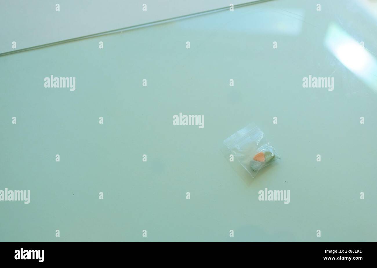Borsetta con pillole di ecstasy Tesla di colore arancione, verde e blu a forma di scudo con il logo Tesla; 240 milligrammi di MDMA Molly ricreativa. Foto Stock