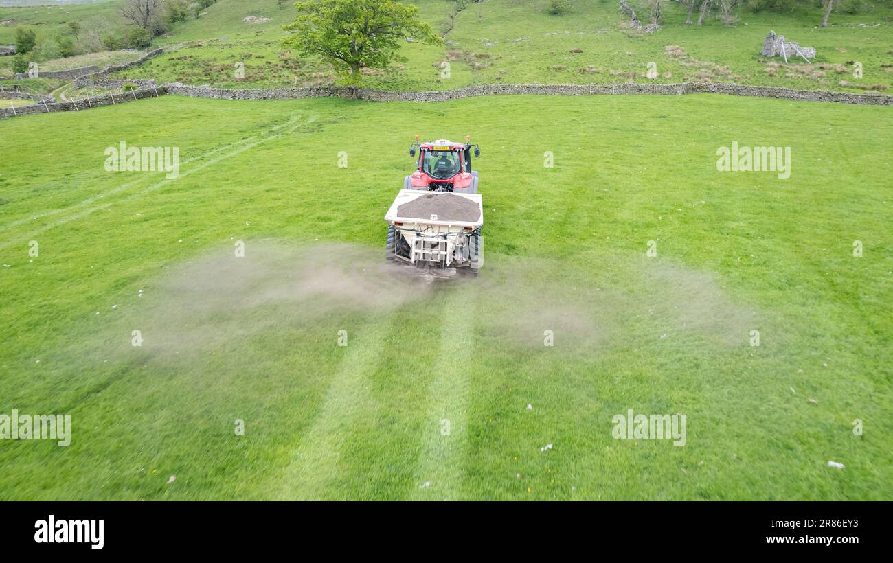 Stendendo calce su un pascolo di altopiano per contribuire ad aumentare la qualità e la fertilità del suolo aumentando il livello di pH. North Yorkshire, Regno Unito. Foto Stock