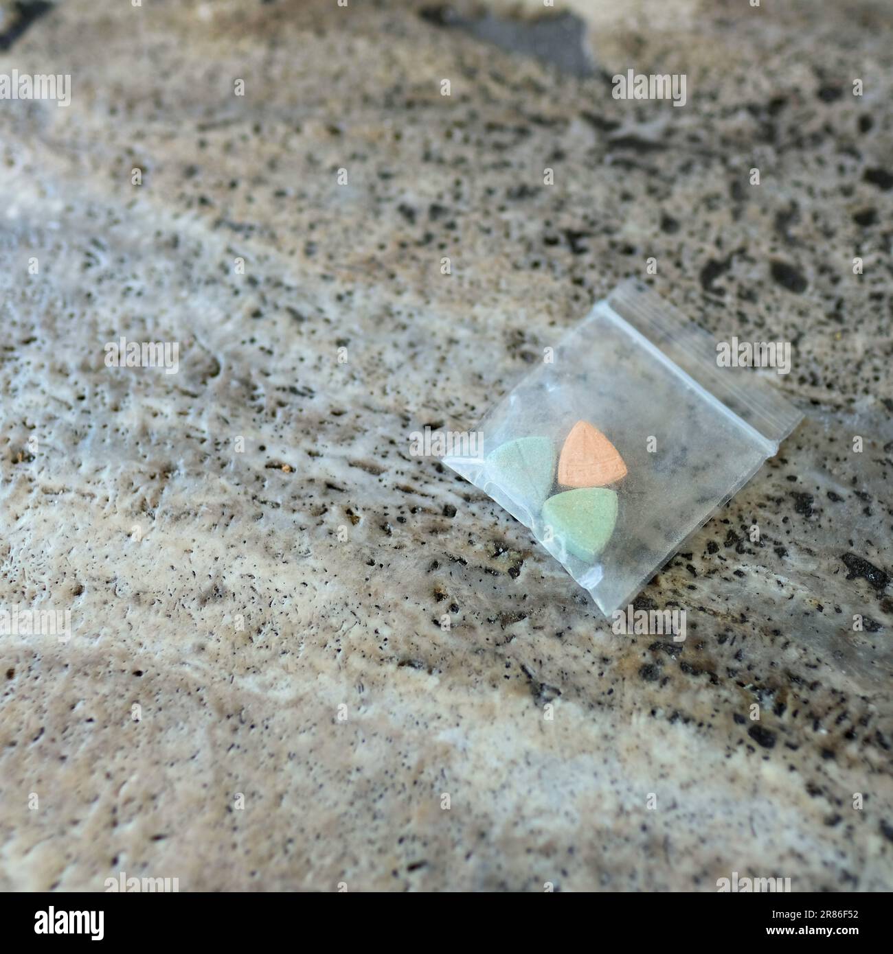 Pillole di ecstasy Tesla di colore arancione, verde e blu a forma di scudo con il logo Tesla; 240 milligrammi di farmaci ricreativi MDMA o Molly Foto Stock