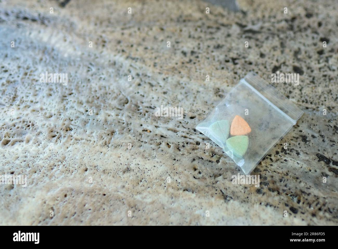 Pillole di ecstasy Tesla di colore arancione, verde e blu a forma di scudo con il logo Tesla; 240 milligrammi di farmaci ricreativi MDMA o Molly Foto Stock