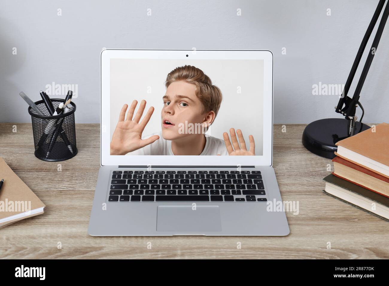 Dipendenza da Internet. Adolescente intrappolato nel notebook. Ragazzo bloccato al monitor dall'interno Foto Stock