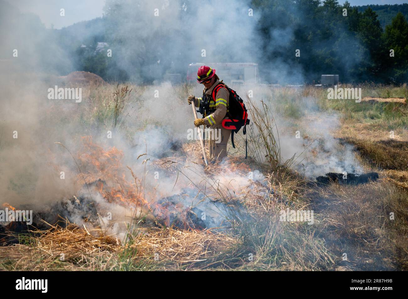 Schweich, Germania. 16th giugno, 2023. Un uomo di Euro-Waldbrand dimostra durante un esercizio come combattere un incendio in un campo agricolo anche con un rastrello. (To dpa text: More Forest Fire - Fire Departments Train for Emergences) Credit: Harald Tittel/dpa/Alamy Live News Foto Stock