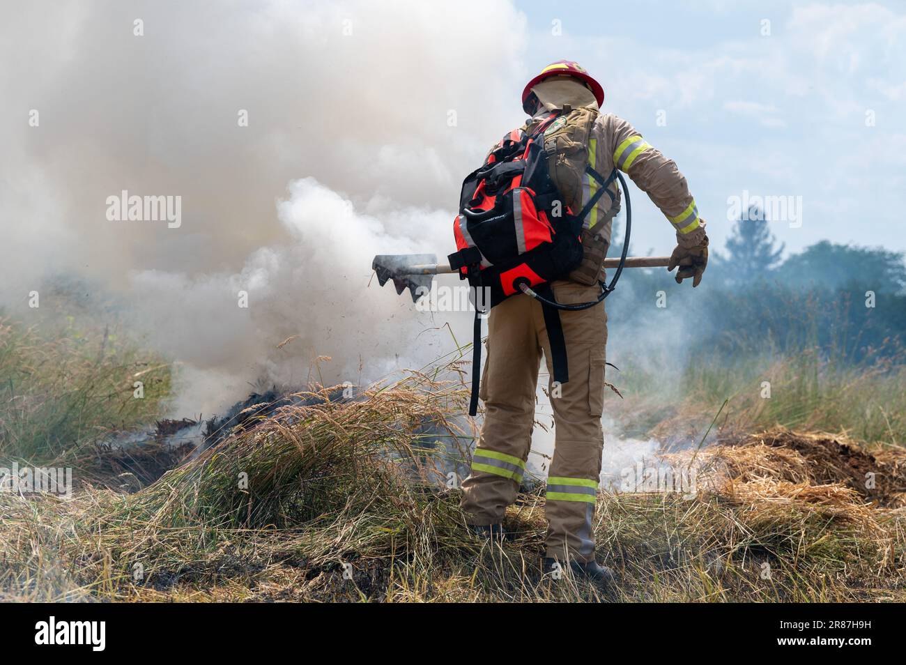 Schweich, Germania. 16th giugno, 2023. Un uomo di Euro-Waldbrand dimostra durante un esercizio come combattere un incendio in un campo agricolo anche con un rastrello. (To dpa text: More Forest Fire - Fire Departments Train for Emergences) Credit: Harald Tittel/dpa/Alamy Live News Foto Stock