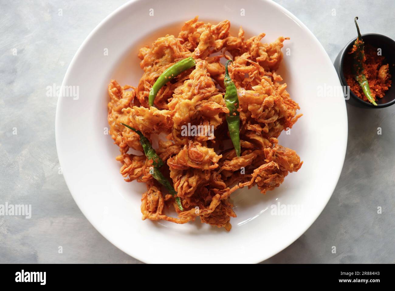 Pakode di cipolla fritta o Pyaj ke Pakore noto anche come Crispy Kanda bhaji, Bhajji, bujji. Spuntino indiano preferito all'ora del tè durante il monsone. Foto Stock