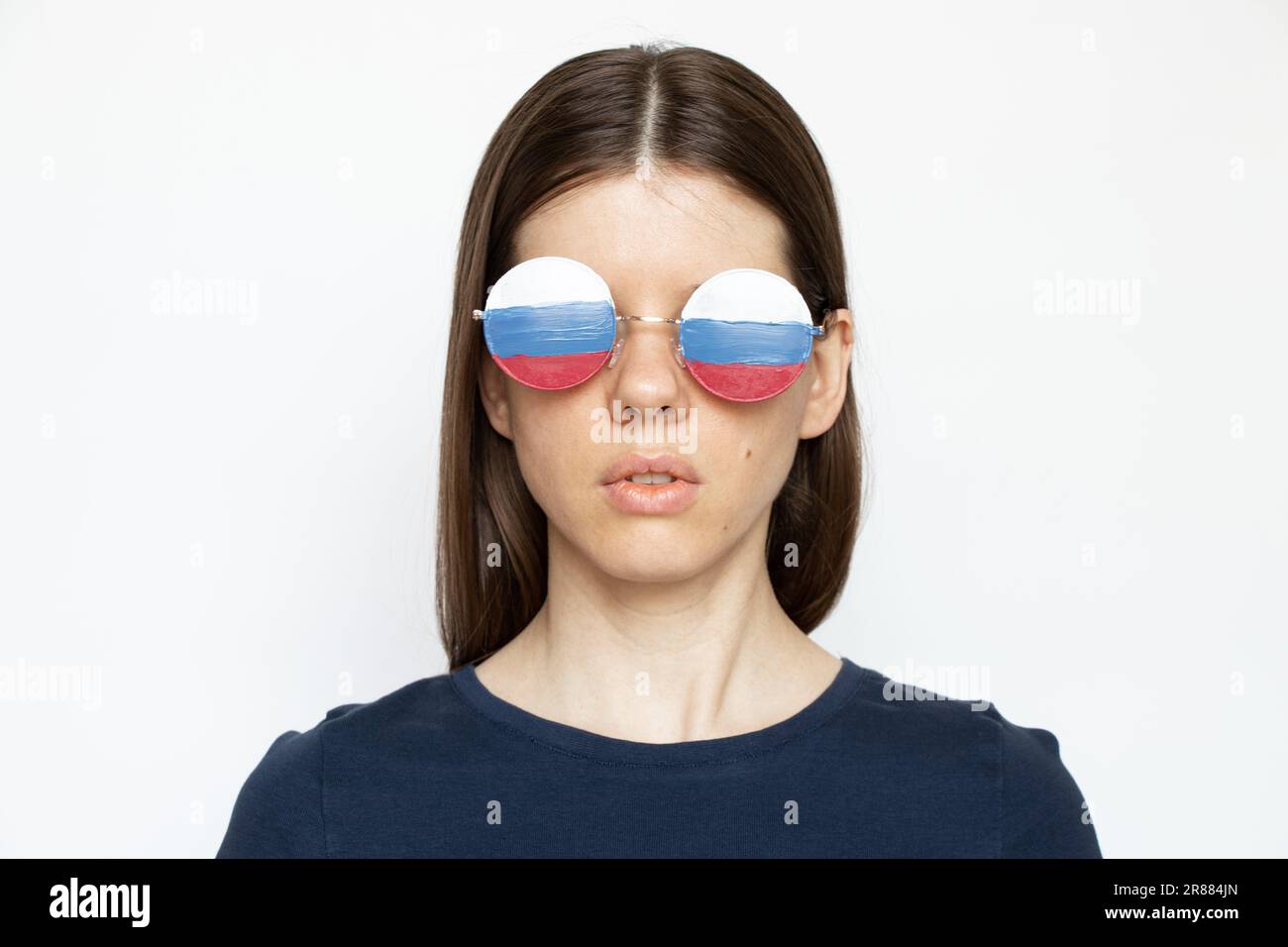 Bandiera della Russia sugli occhiali di una ragazza su sfondo bianco, cieca e ingannata propaganda della Russia, non vede nulla a causa della propaganda Foto Stock
