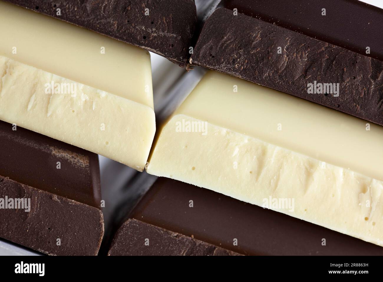 Pile di cioccolato nero, marrone e bianco su sfondo bianco Foto Stock