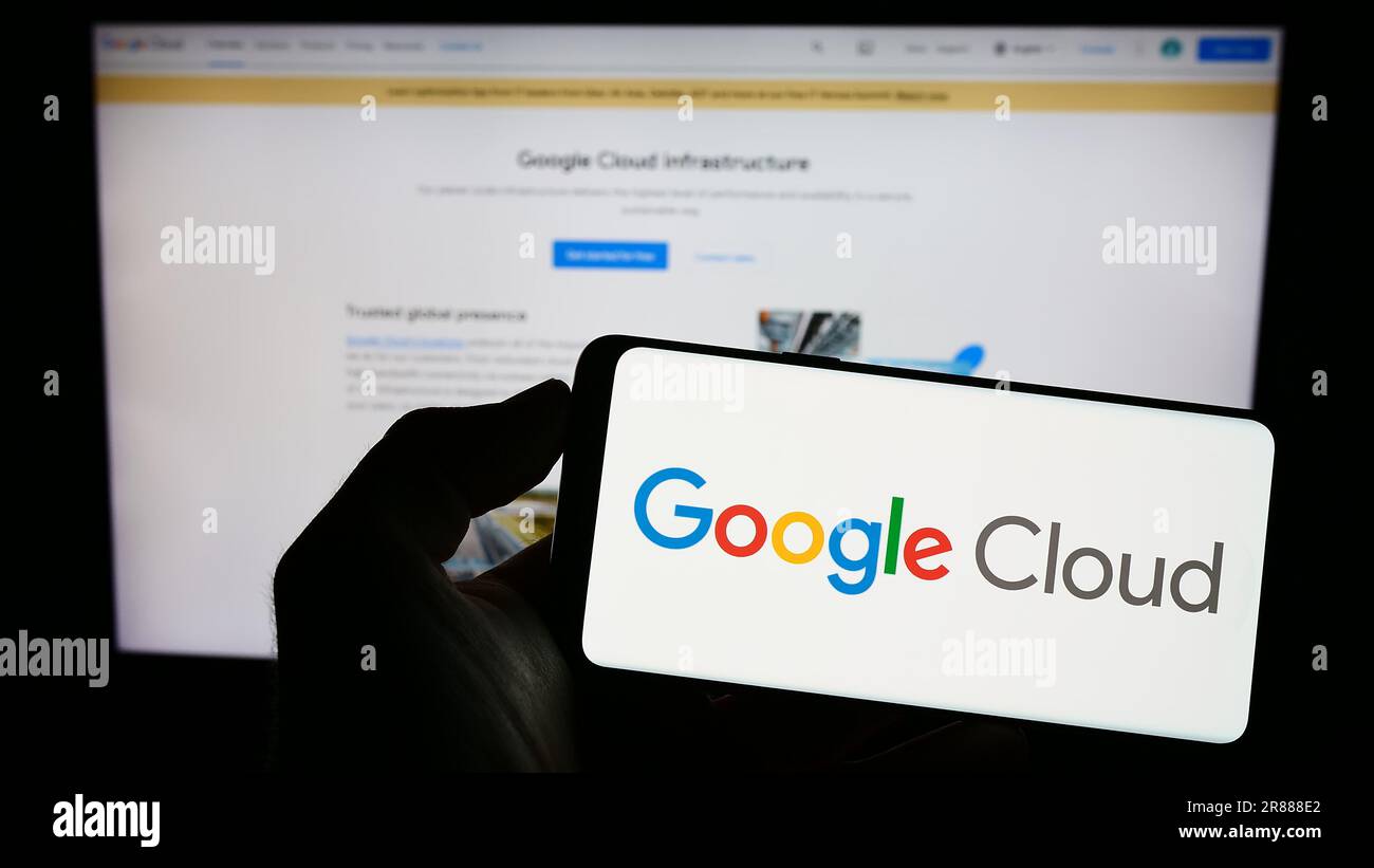 Persona che possiede un cellulare con il logo dei servizi di elaborazione Google Cloud Platform (GCP) sullo schermo davanti alla pagina Web. Concentrarsi sul display del telefono. Foto Stock