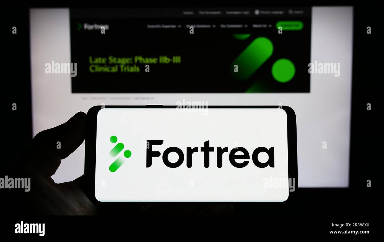 Persona che detiene lo smartphone con il logo della società sanitaria statunitense Fortrea Inc. Sullo schermo di fronte al sito Web. Concentrarsi sul display del telefono. Foto Stock