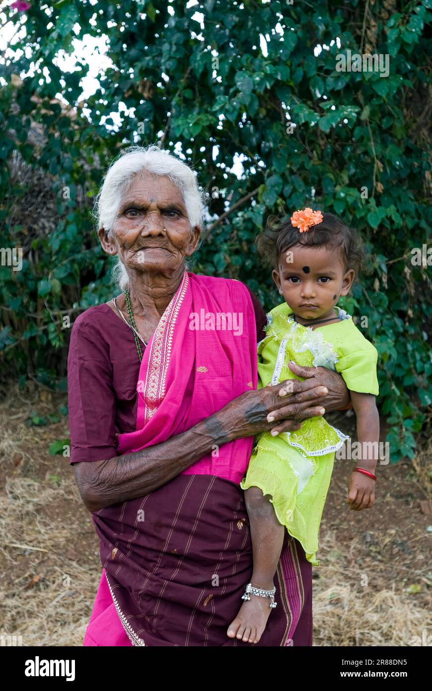 Nonna che tiene la nonna nella sua anca, Tamil Nadu, India Foto Stock