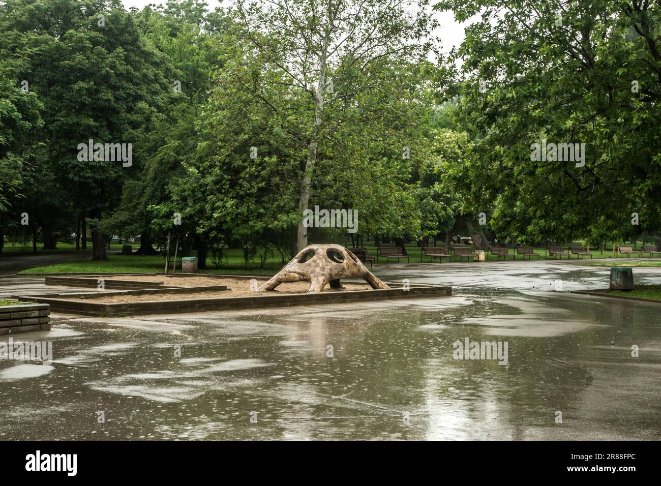 Parco cittadino con campo di sabbia per bambini in caso di pioggia Foto Stock