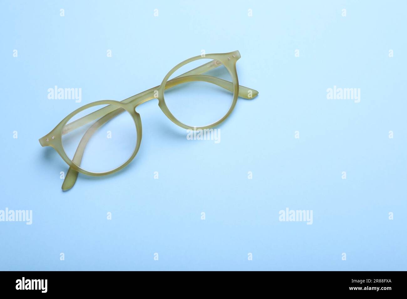 Occhiali con lenti correttive su sfondo azzurro, vista dall'alto. Spazio per il testo Foto Stock