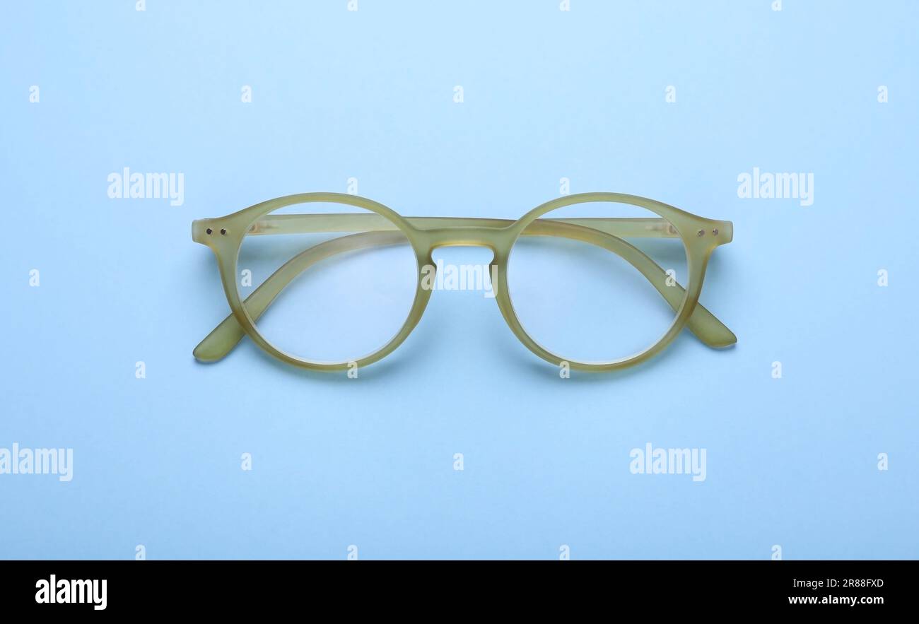 Occhiali con lenti correttive su sfondo azzurro, vista dall'alto Foto Stock
