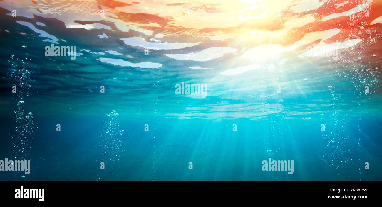 Oceano subacqueo con Tramonto - Abisso con luce solare - Abstract sfondo sfocato ed effetto luminoso Foto Stock