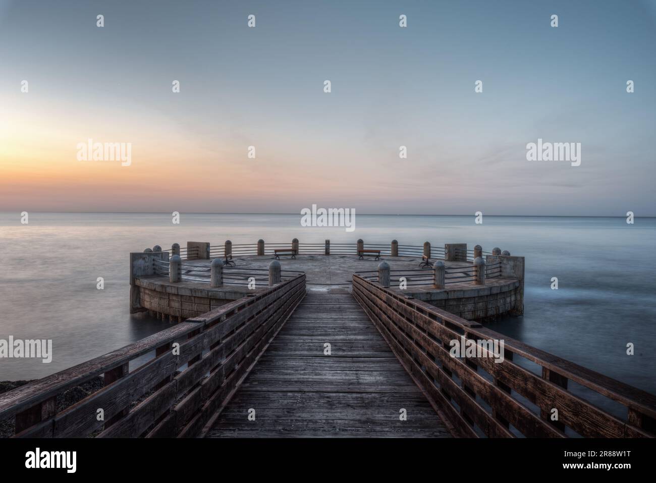 Mattina sul molo e la rotonda che si affaccia sul mare con gli splendidi colori dell'alba Foto Stock