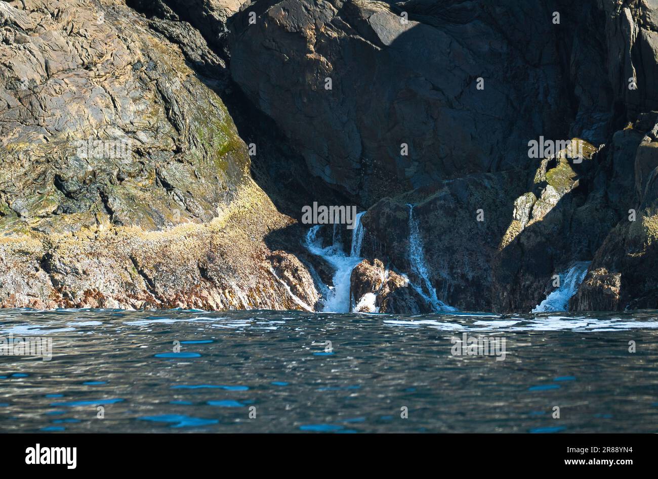 norvegia sul fiordo, spruzzare sulle rocce. Spruzzi d'acqua sulle pietre. Paesaggio costiero in Scandinavia. Foto del paesaggio da nord Foto Stock