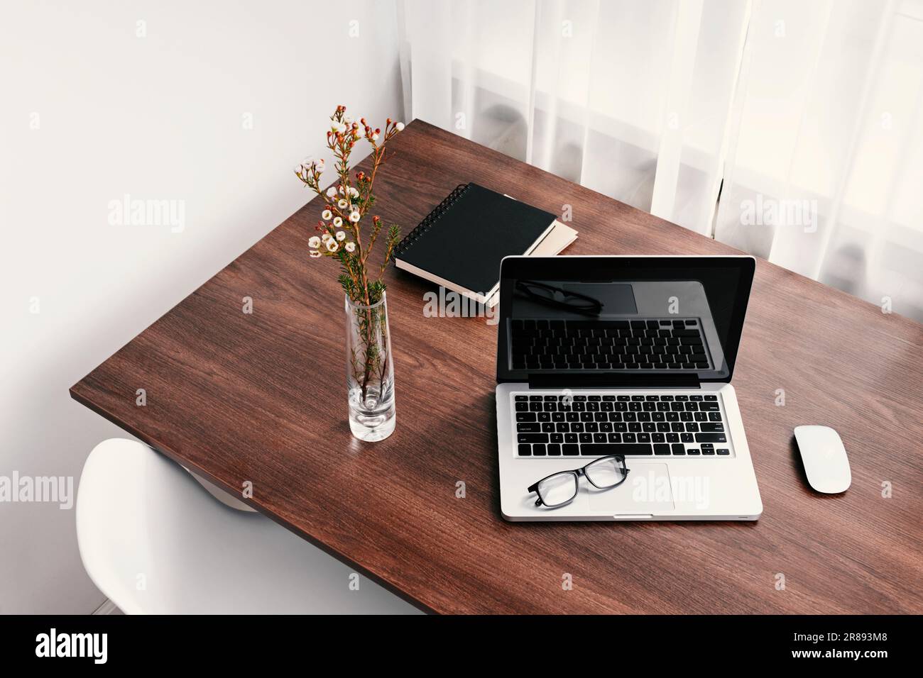 Un moderno computer portatile su una scrivania, con occhiali Foto Stock