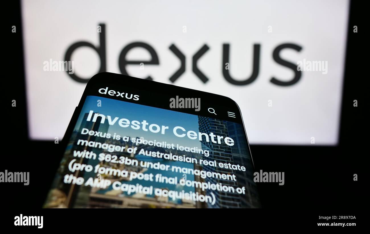 Smartphone con il sito Web della società immobiliare australiana Dexus Group sullo schermo davanti al logo aziendale. Mettere a fuoco in alto a sinistra sul display del telefono. Foto Stock