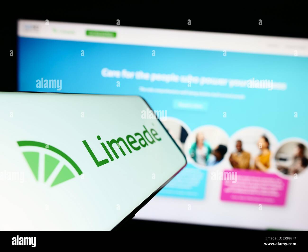 Cellulare con il logo della società americana di benessere dei dipendenti Limeade Inc. Sullo schermo davanti alla pagina Web. Concentrarsi sul centro del display del telefono. Foto Stock