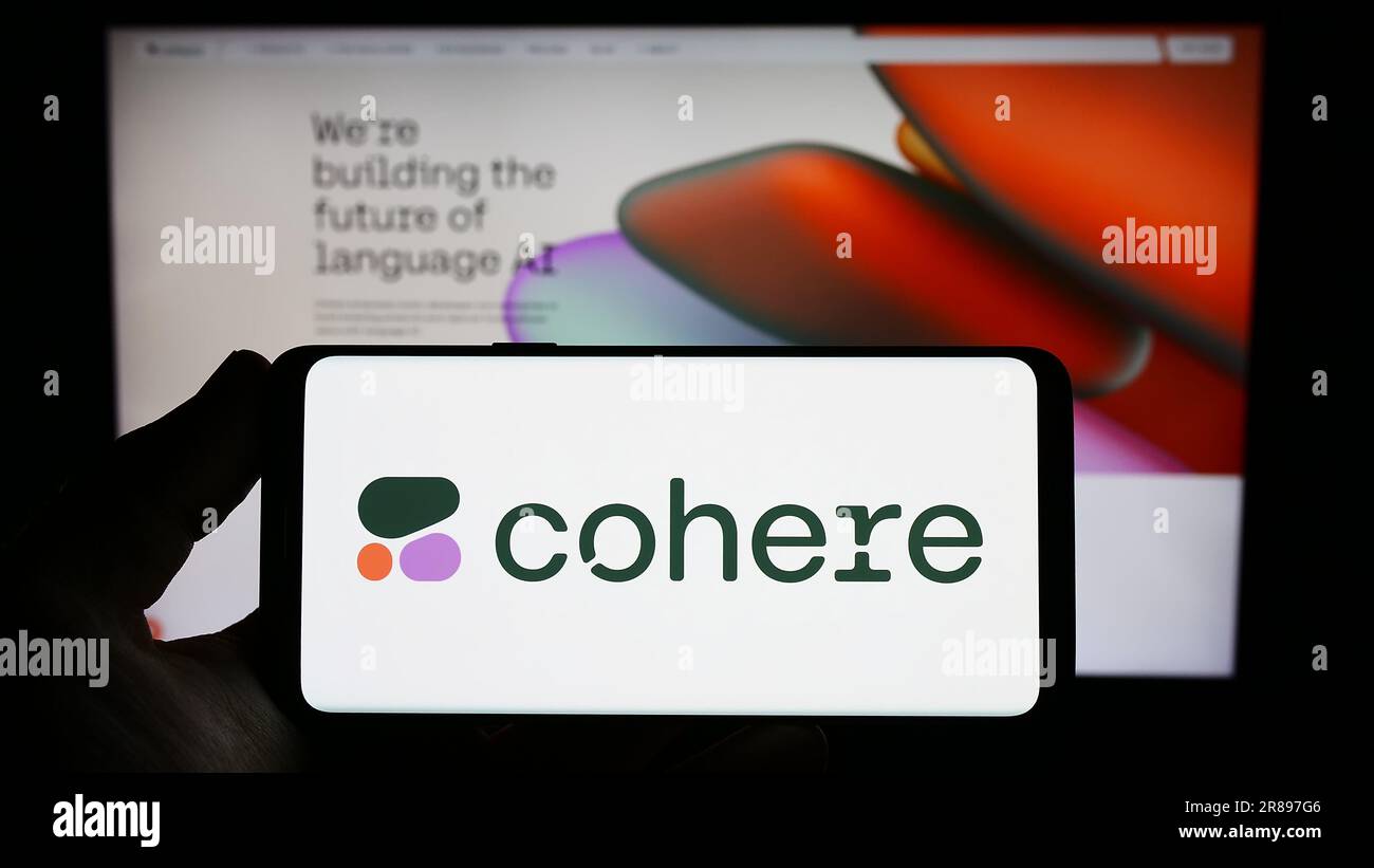 Persona che possiede uno smartphone con il logo della società canadese di intelligenza artificiale Cohere Inc. Sullo schermo di fronte al sito Web. Concentrarsi sul display del telefono. Foto Stock