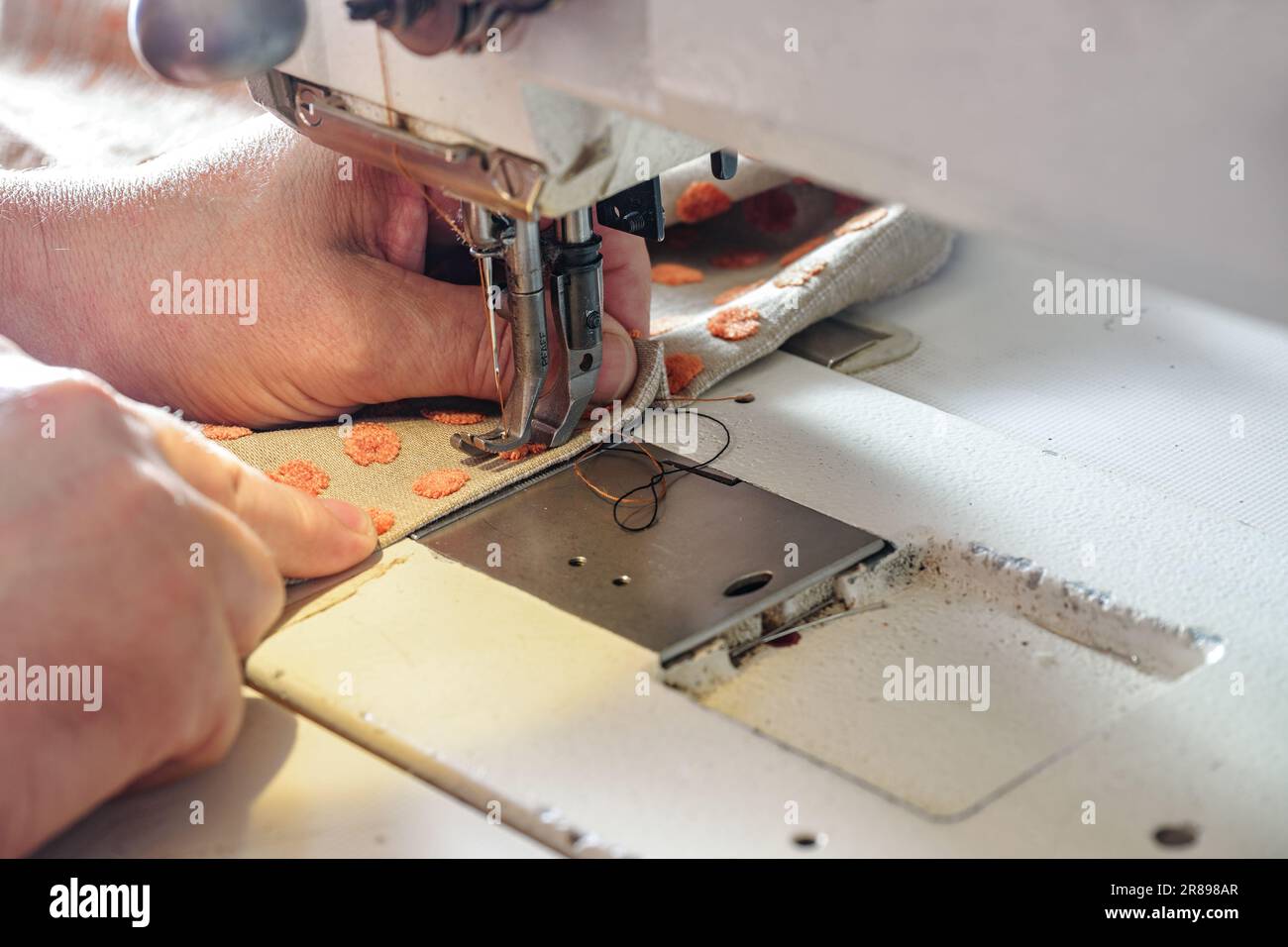 Interior designer che lavora su una macchina da cucire industriale con tessuto per tappezzeria, tende o decorazione casa copia spazio, focus selezionato, stretta d Foto Stock
