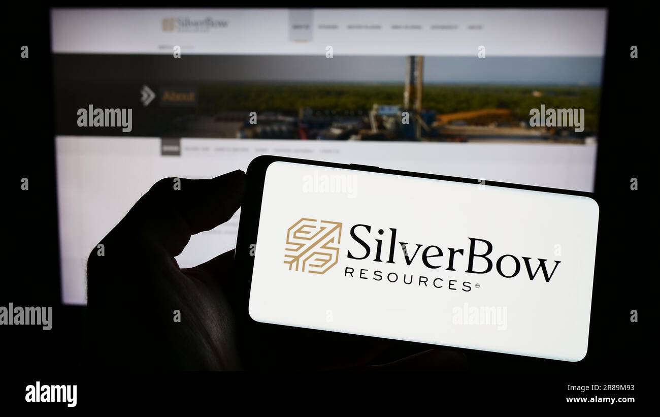 Persona che possiede uno smartphone con il logo della società statunitense di petrolio e gas SilverBow Resources Inc. Sullo schermo di fronte al sito Web. Concentrarsi sul display del telefono. Foto Stock