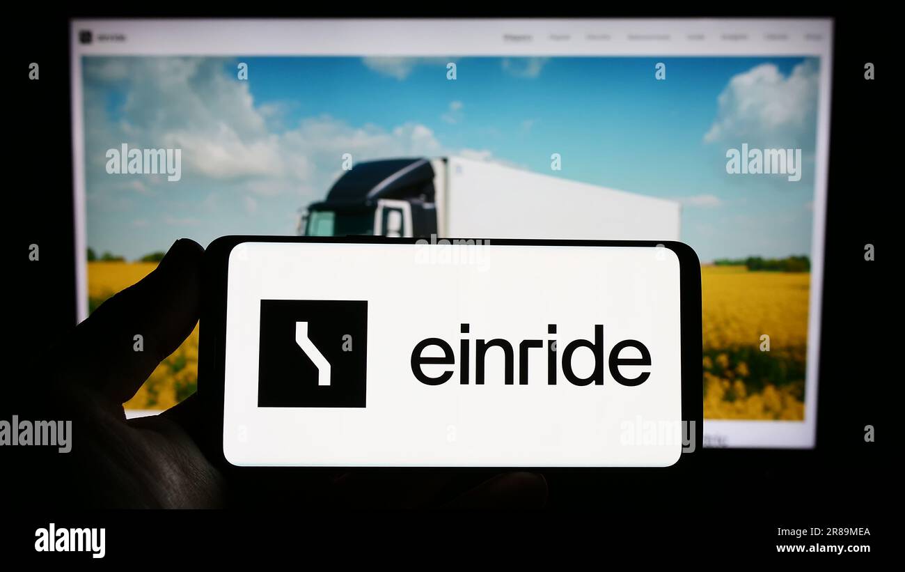 Persona che possiede uno smartphone con il logo della società svedese di mobilità elettrica Einride AB sullo schermo di fronte al sito Web. Concentrarsi sul display del telefono. Foto Stock